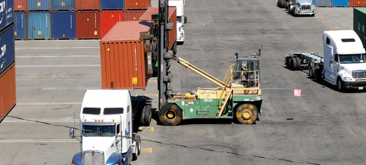 Cargo-handling equipment loading container on truck.